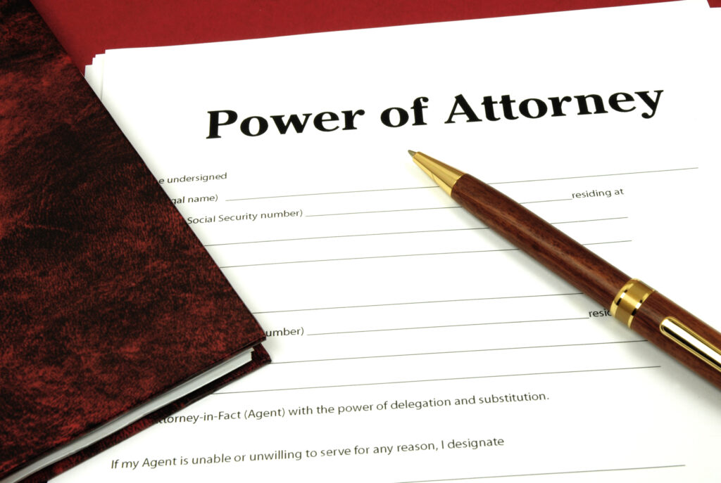 Paper with the title "Power of Attorney" and brown pen on top of the paper