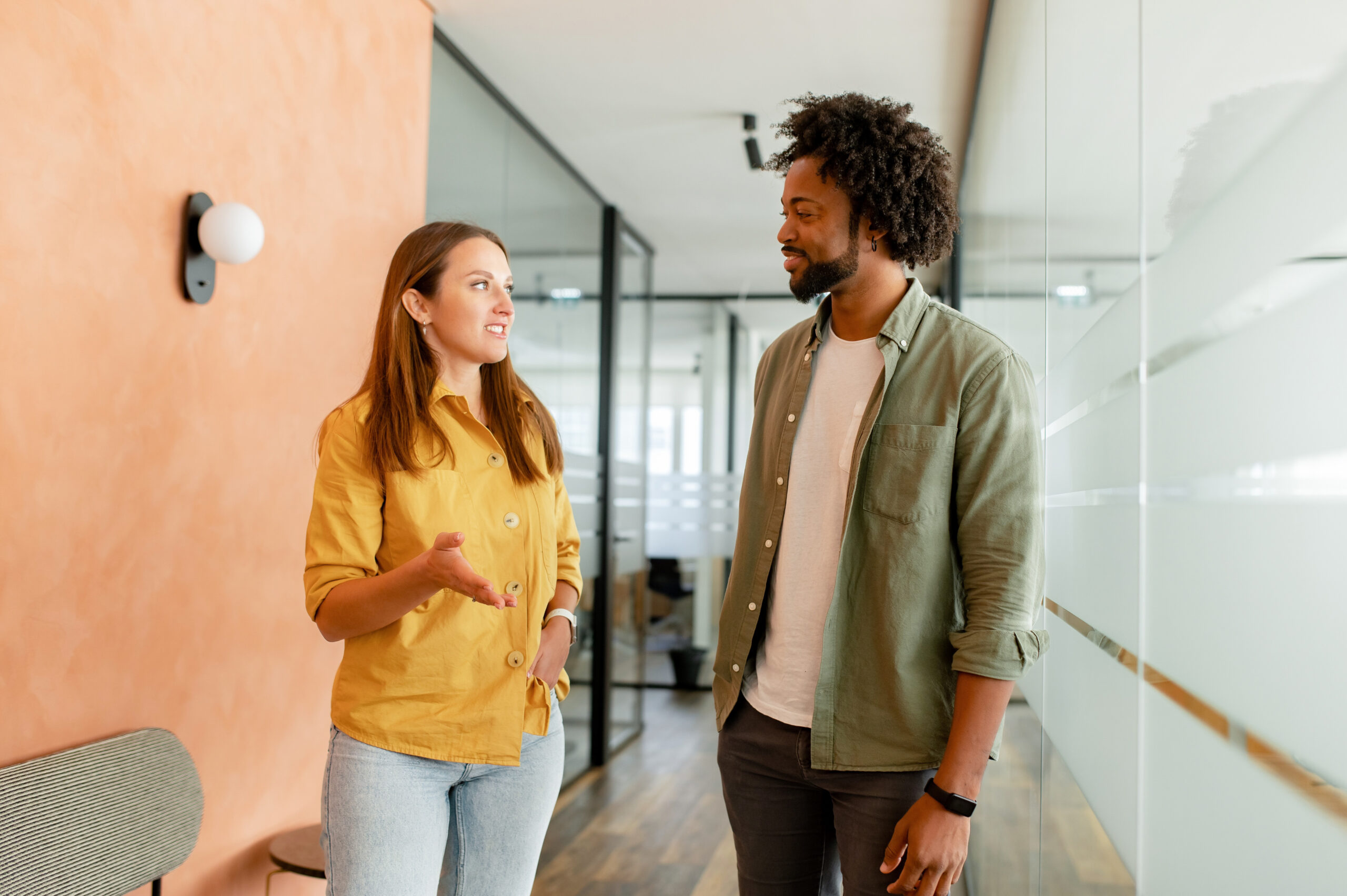 A man and woman standing in a hallway talking