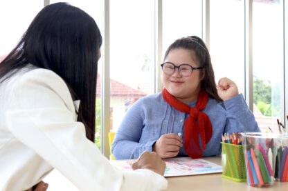 Disabled kids classroom, children having fun during study at school, kids learning and playing together, schoolgirl having fun with teacher in art classroom