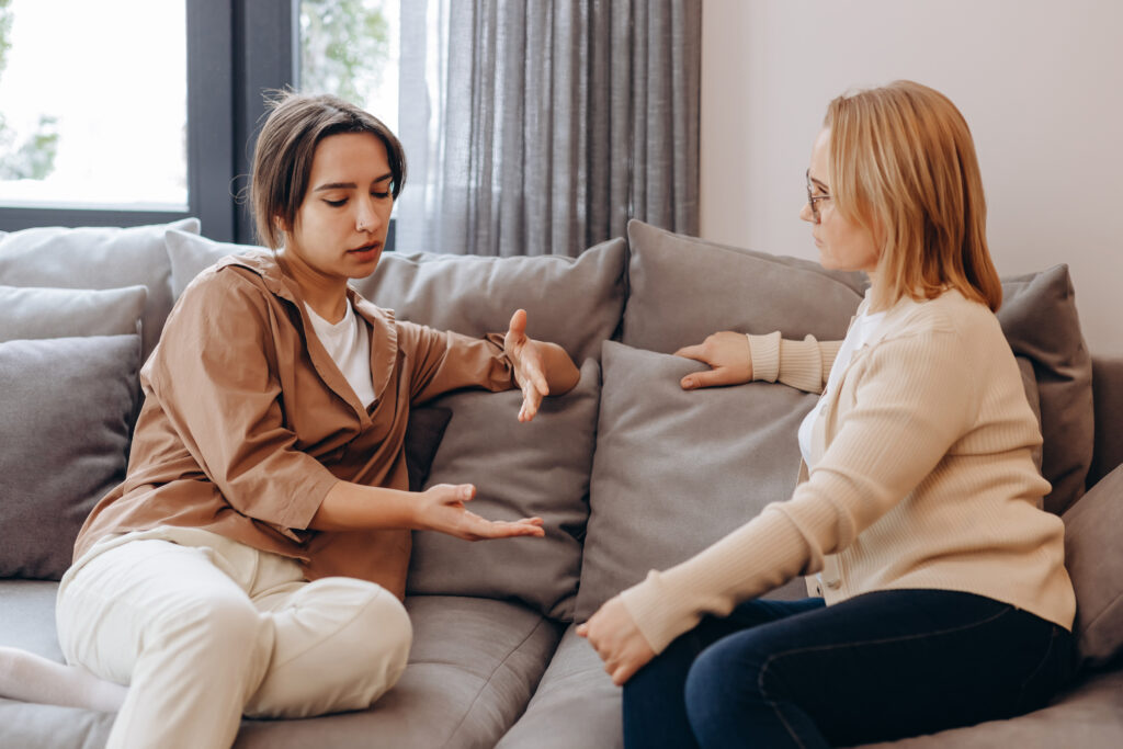 Two women sitting on a couch talking