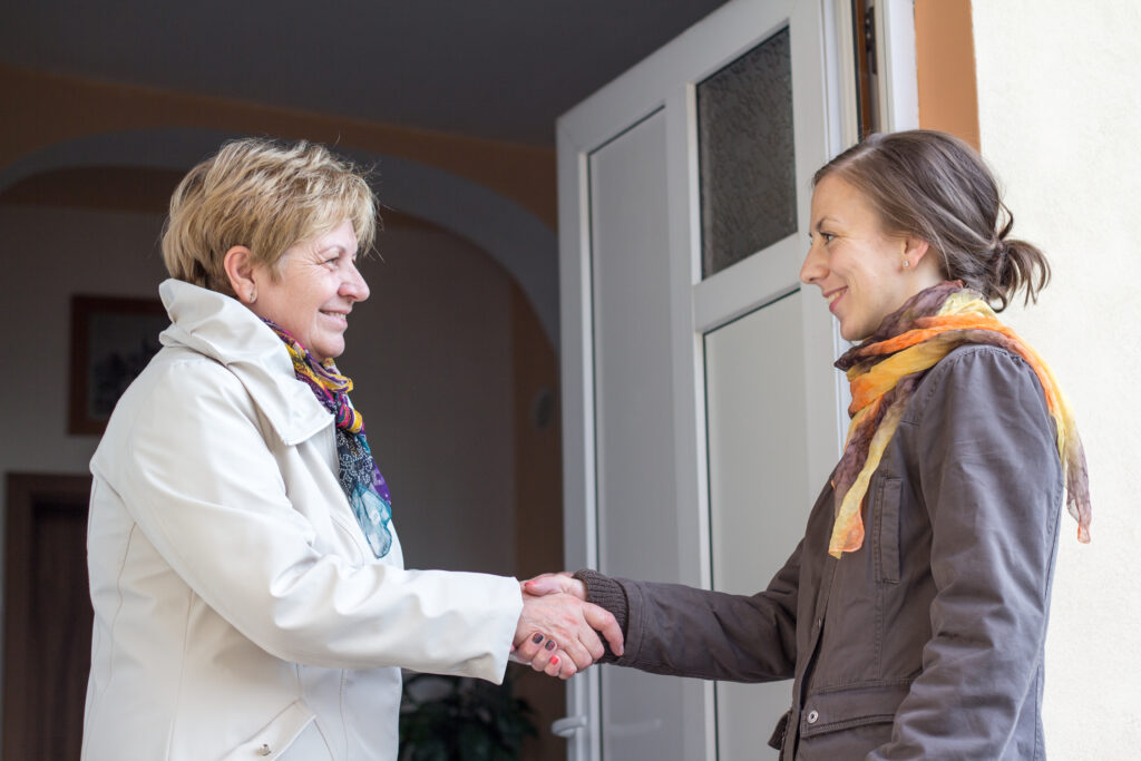 Senior women greeting young girl in the doorway