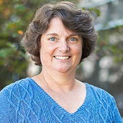 Headshot of Christine Hausman in front of trees 