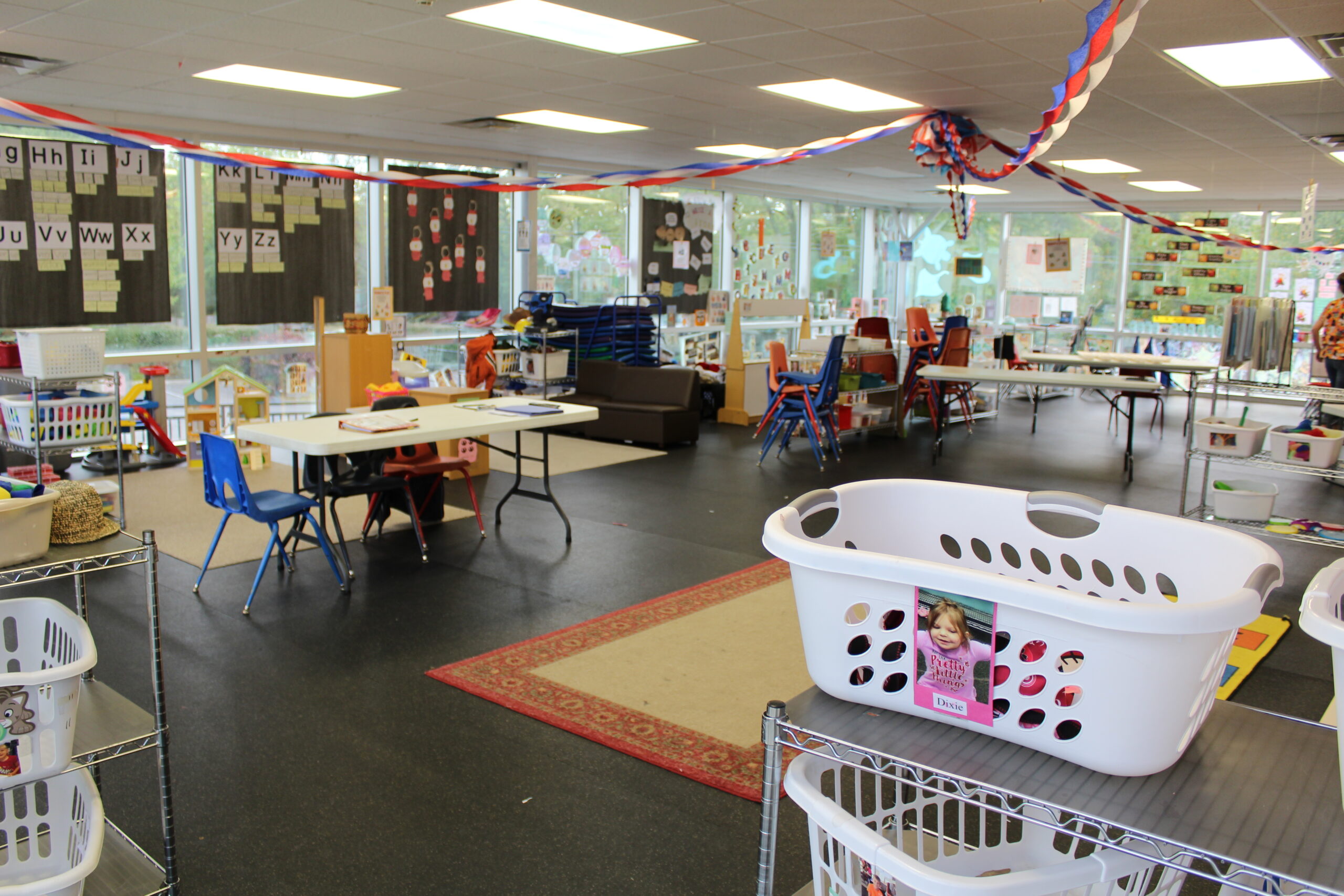 View of a child care classroom arranged neatly with shelves and tables.