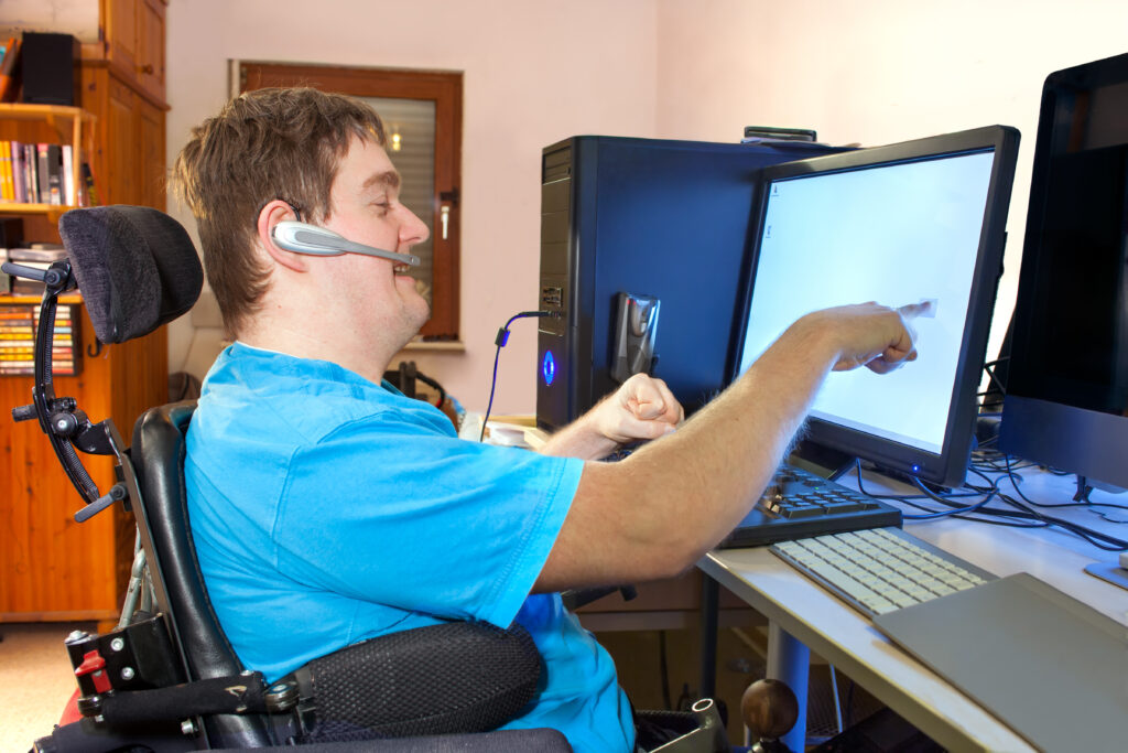 Disabled man at the computer using assistive technology