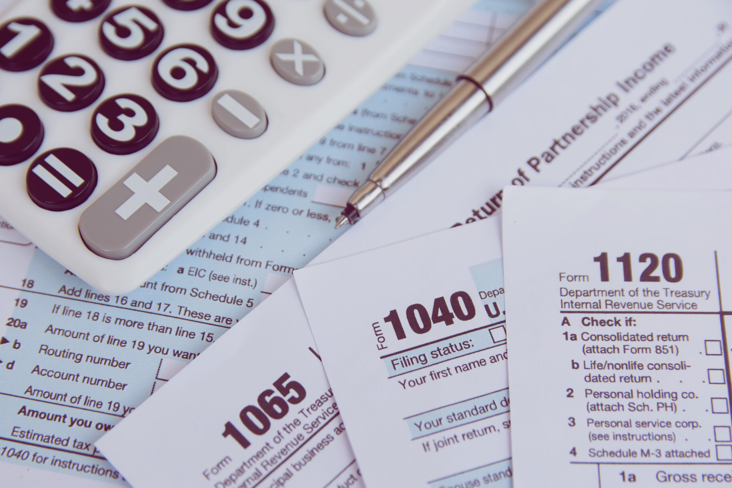 Tax season. calculator, pen on US tax form background